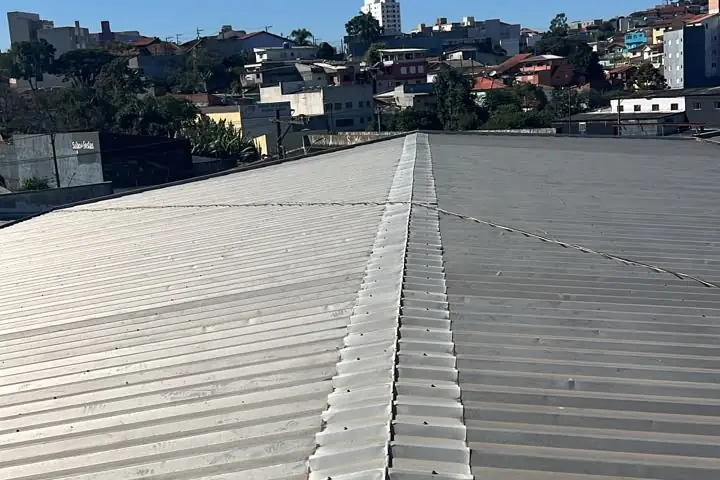 Telhado residencial de telhas cerâmicas com a cidade ao fundo